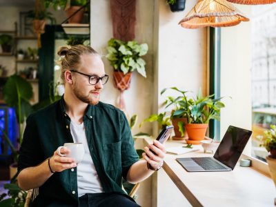 Student Using Smartphone While Drinking Coffee